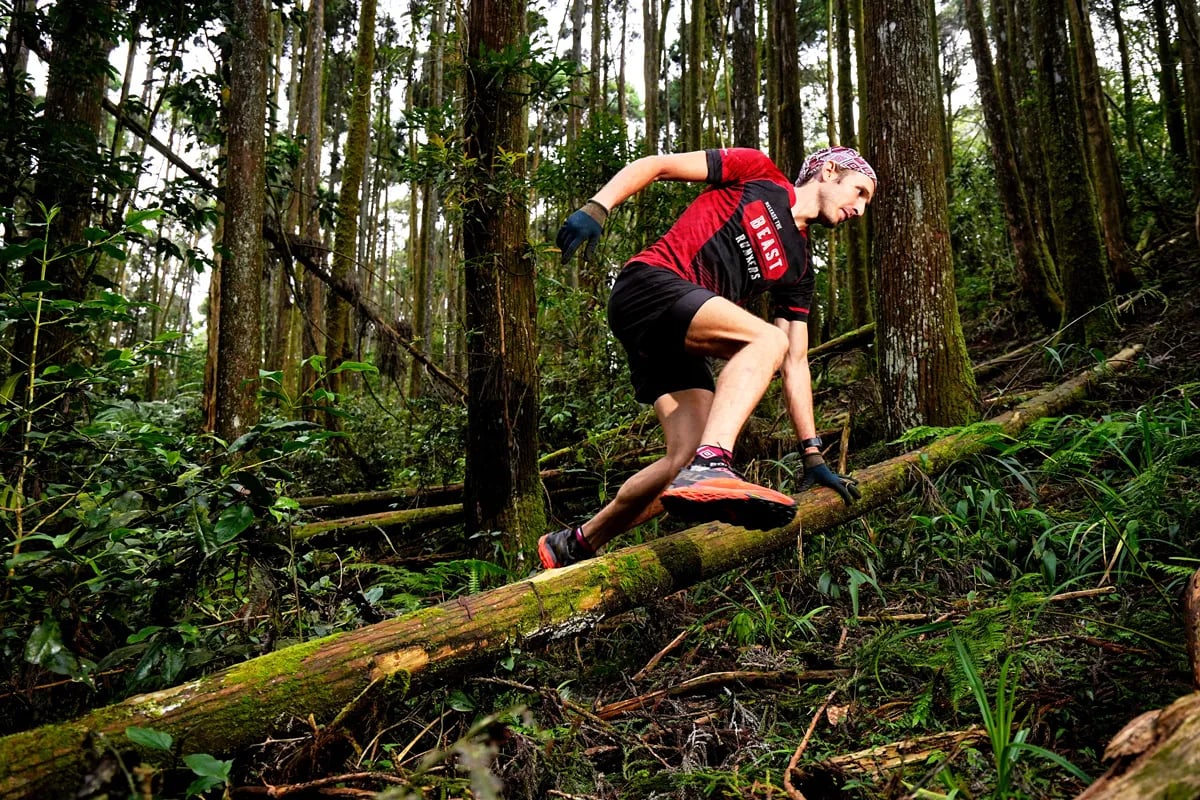 Petr Novotny runs over a moss-covered log on a forest trail in Taiwan.