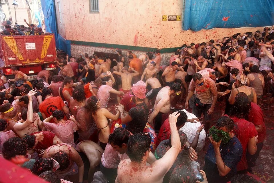 People covered in tomato pulp during La Tomatina in Buñol, Spain.