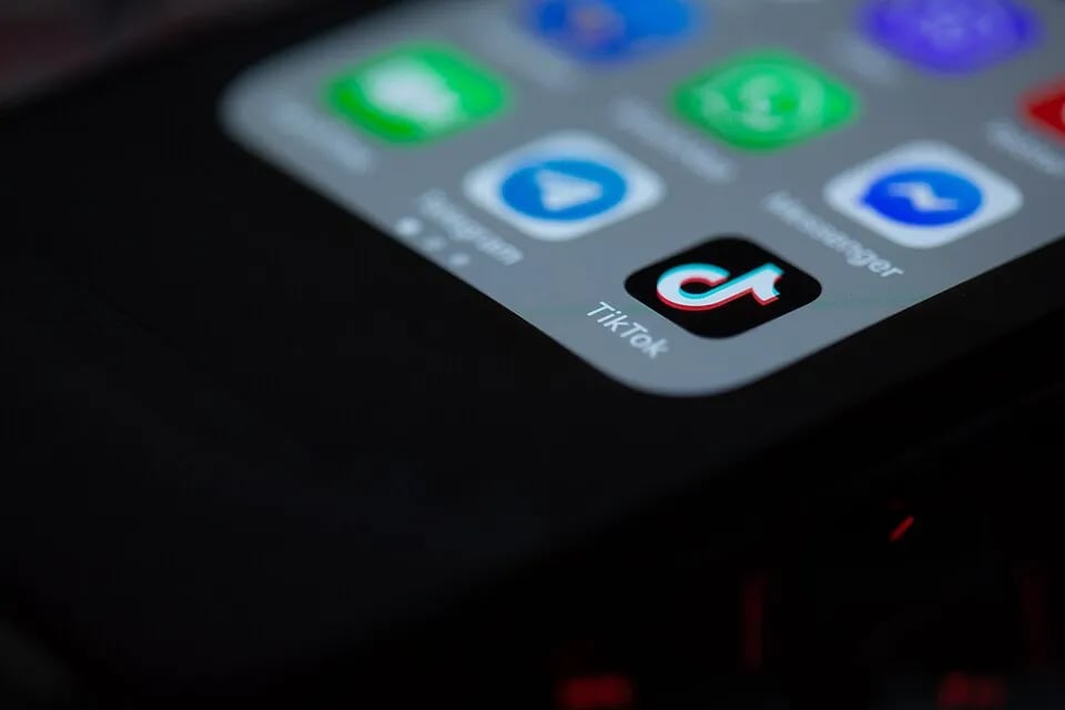 The TikTok app icon appears on a smartphone screen.