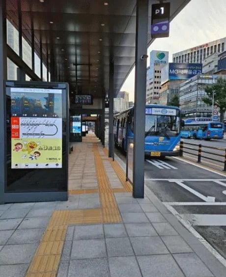 The interior of a Seoul Smart Shelter beside a city bus lane.