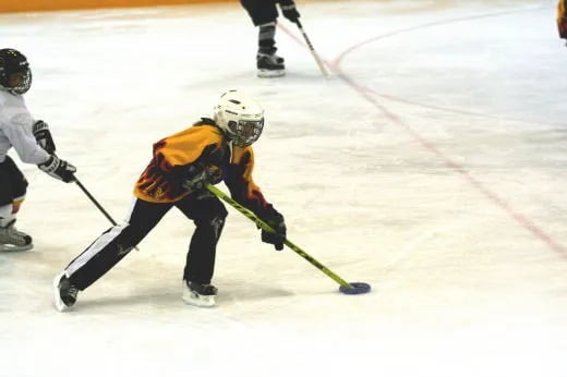 A ringette player skating with the ring during a game in Ontario, Canada.