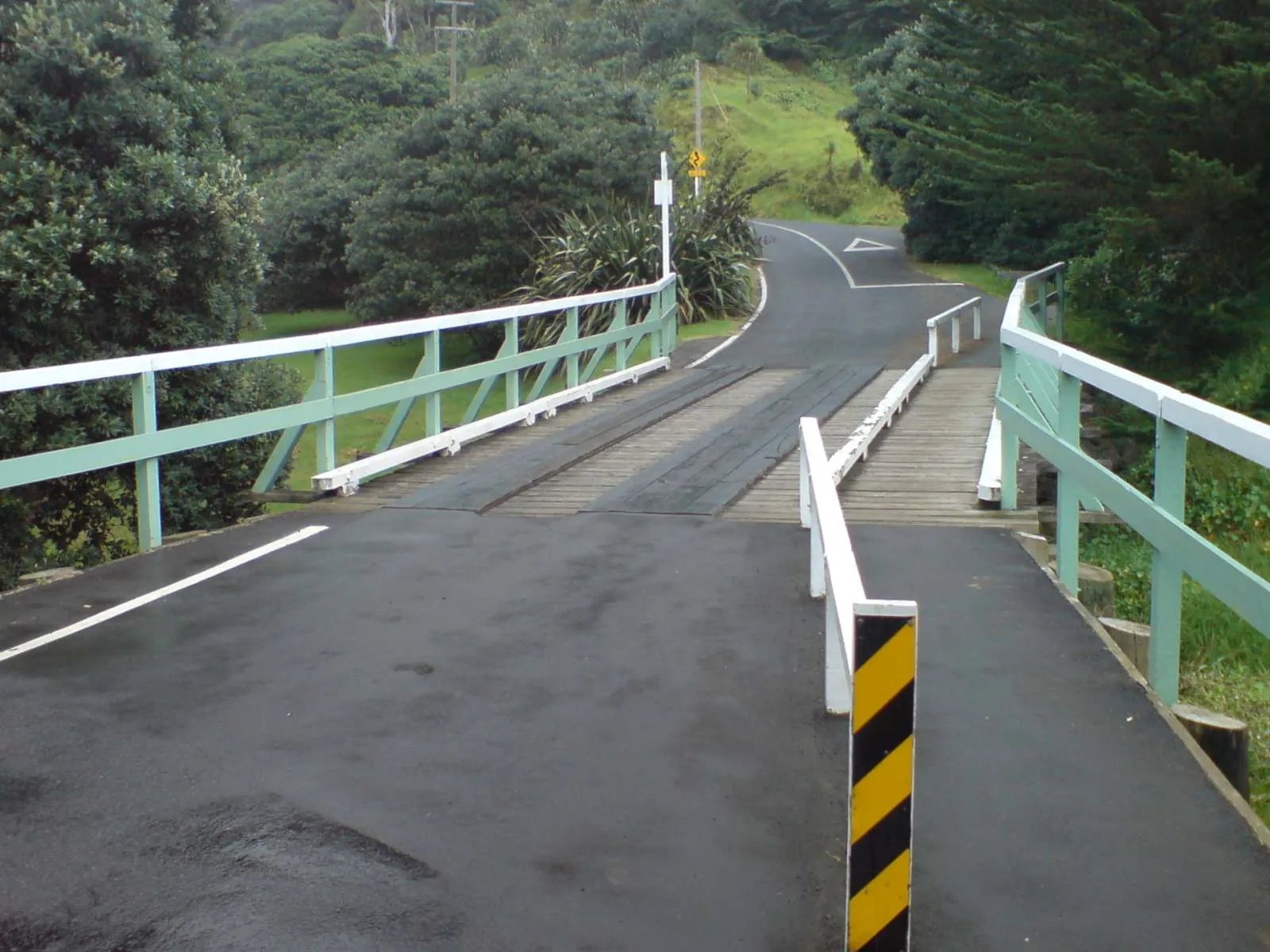 A narrow single-lane bridge on a rural road in west Auckland, New Zealand.