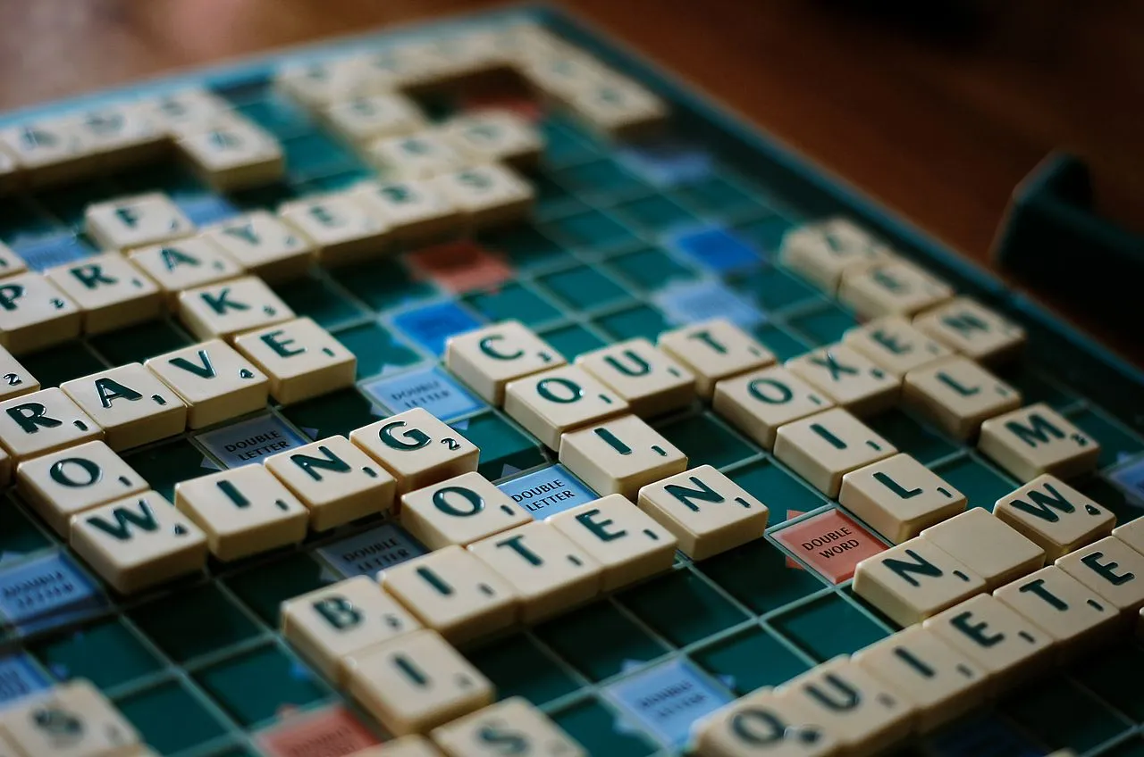 Close-up of an English-language Scrabble board mid-game, with tiles spelling out interlocking words.
