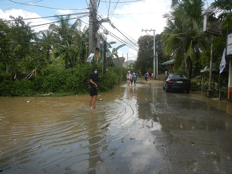 An archival photograph shows residents walking through a flooded street in Calumpit, Bulacan.