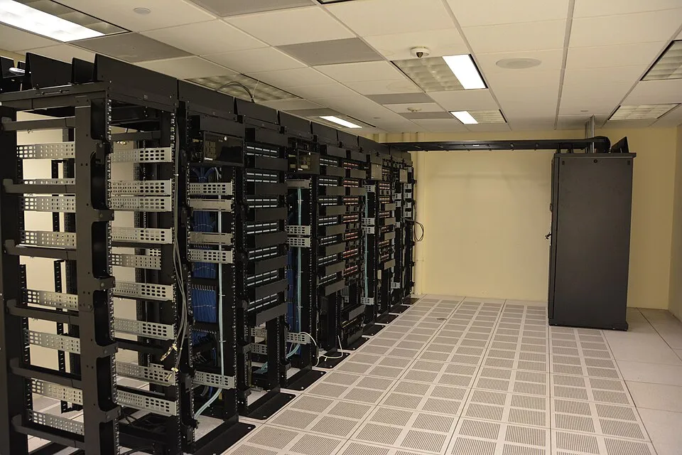 Rows of server racks in a data center, representing the secured computing environments used to train and evaluate advanced AI systems.