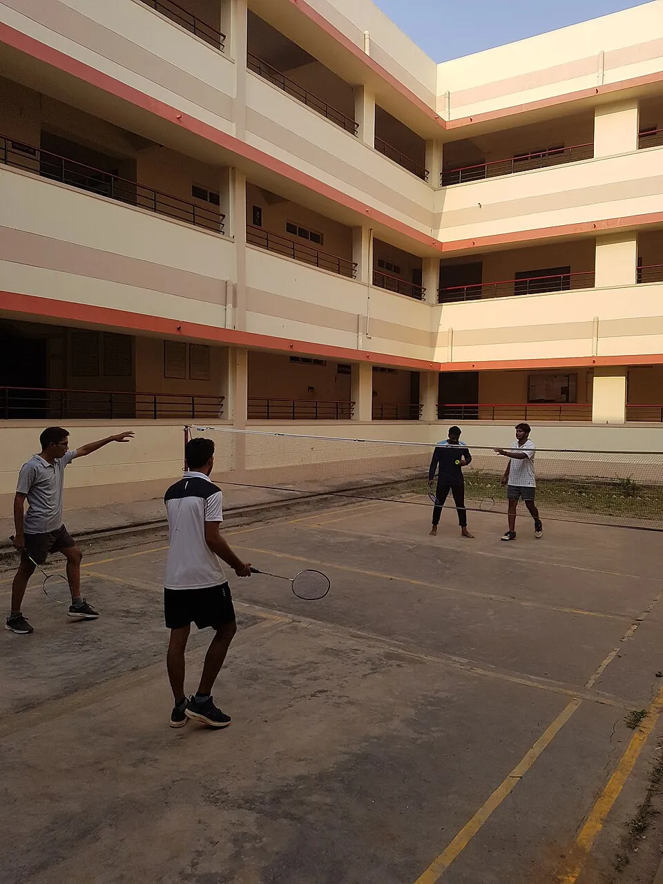 Players take part in a badminton game on an outdoor court in India.