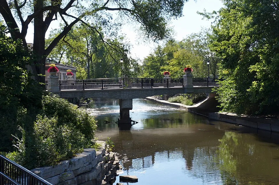 A bridge crosses the DuPage River along the green Riverwalk in suburban Naperville, Illinois.