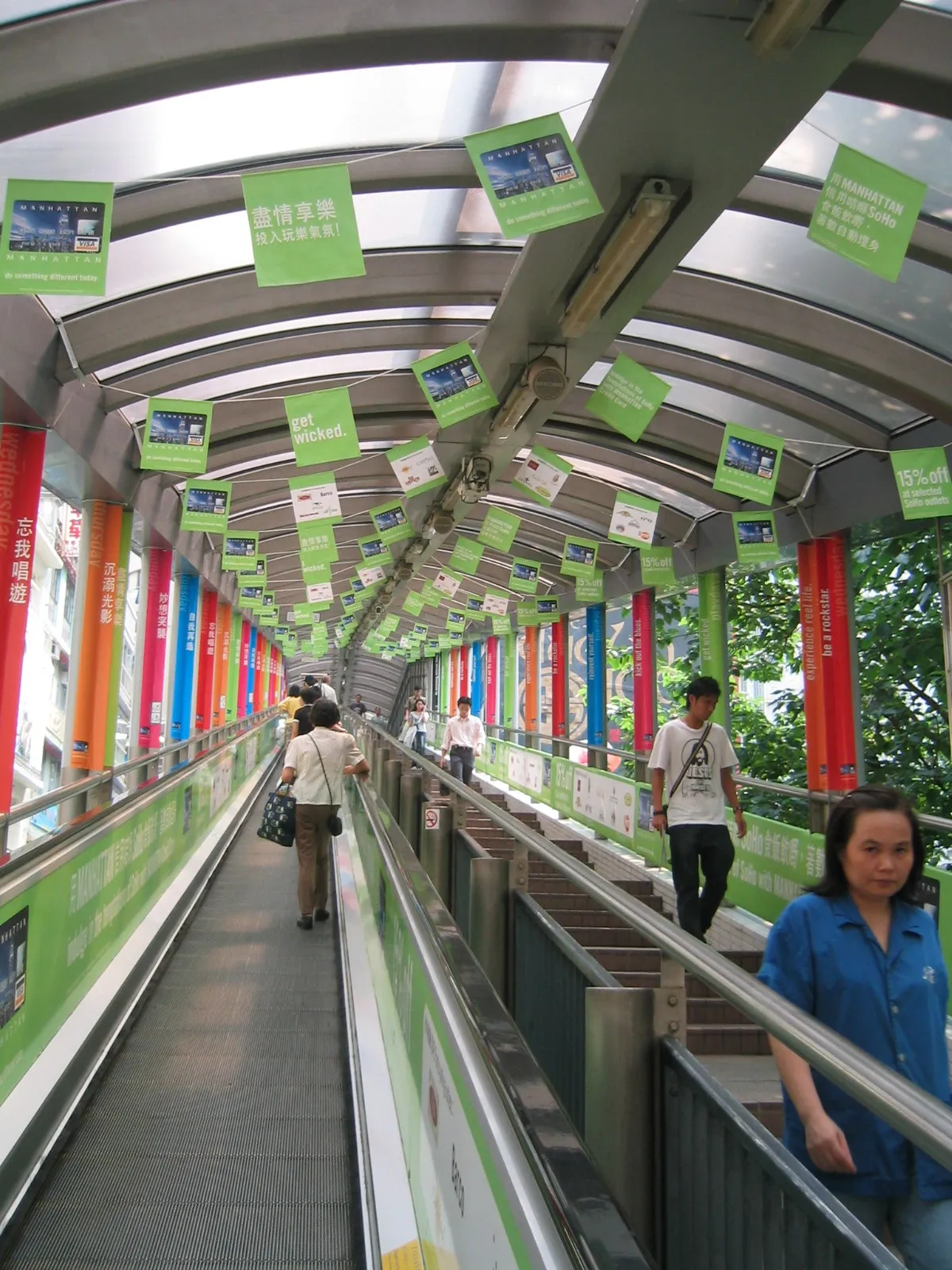 People ride the covered Central–Mid-Levels Escalator in Hong Kong.