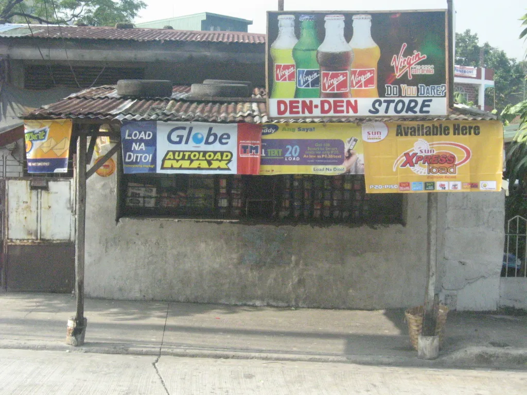 A small sari-sari store displays snacks, drinks and household products behind its front window.